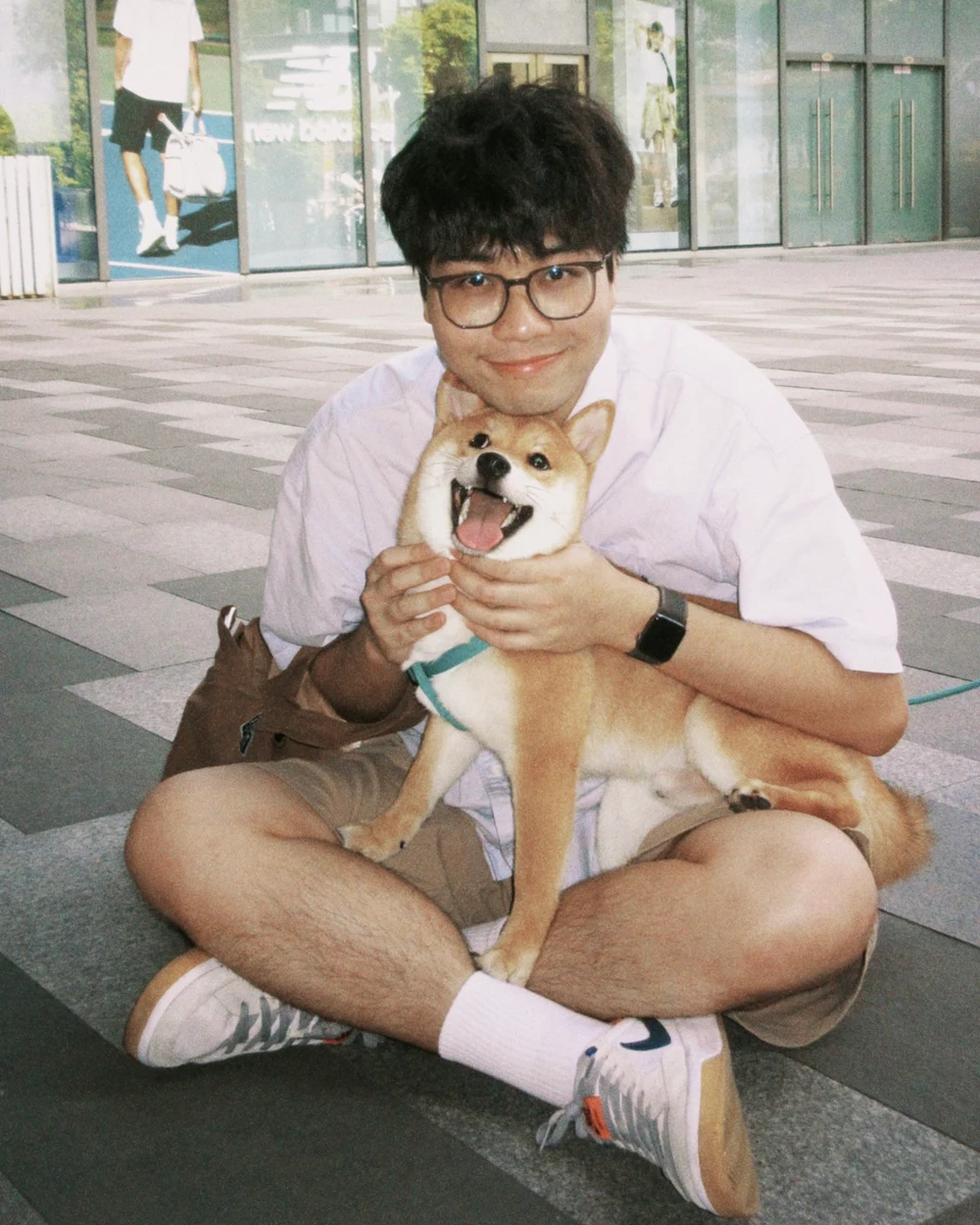 吴凌晞抱着一只柴犬坐在台阶前